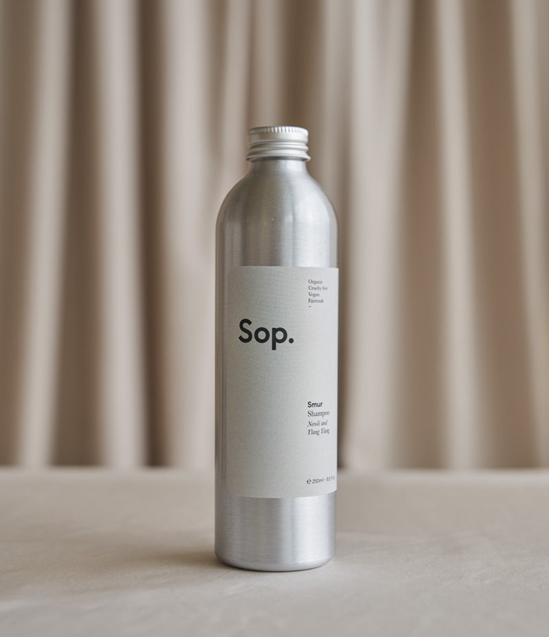 Image shows an aluminium bottle of Sop Smur Shampoo - Neroli and Ylang Ylang 250ml against a light coloured background- Nor–Folk