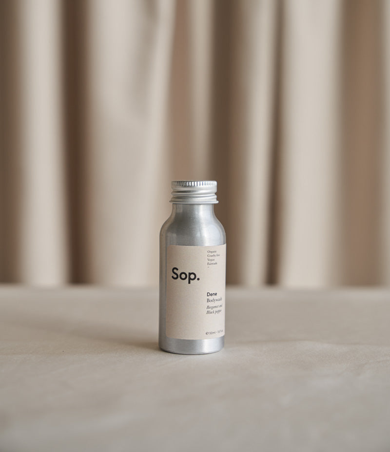 Image of an aluminium  bottle of Sop Dene Bodywash - Bergamot & Black Pepper 50ml against a light coloured background- Nor–Folk
