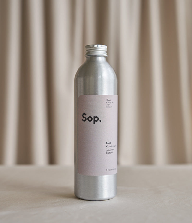 Image of an aluminium bottle of Sop Loke Conditioner - Juniper and grapefruit 250ml against a light coloured background- Nor–Folk
