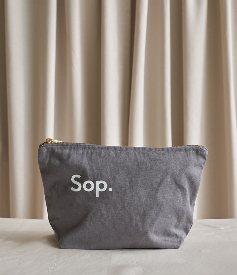  Image shows a grey Wash Bag with a white Sop logo on the middle left of the bag. Sitting against a light coloured background - Nor–Folk
