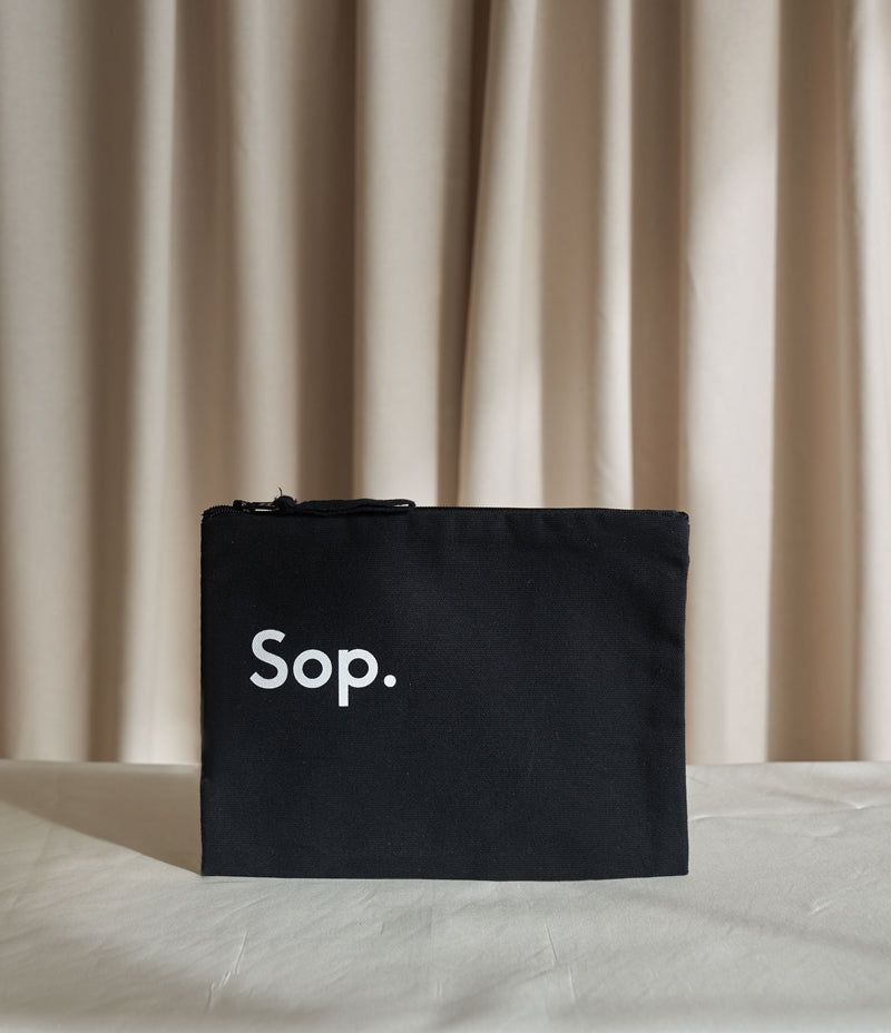 Image of a black Sop Travel / Make Up Bag with a white Sop logo on the middle left of the bag. Against a light coloured background - Nor–Folk